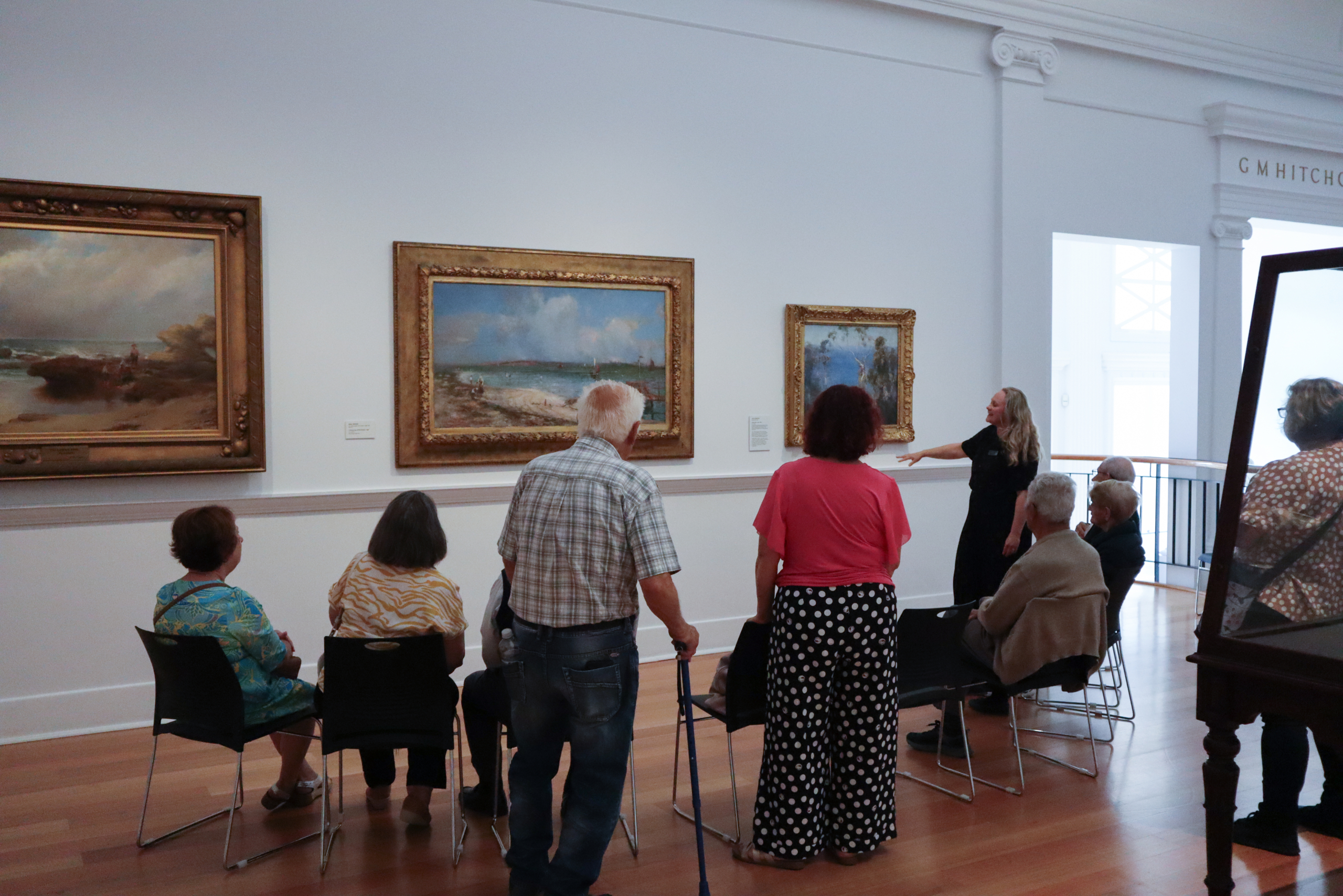 Visitors viewing an artwork with a Geelong Gallery guide