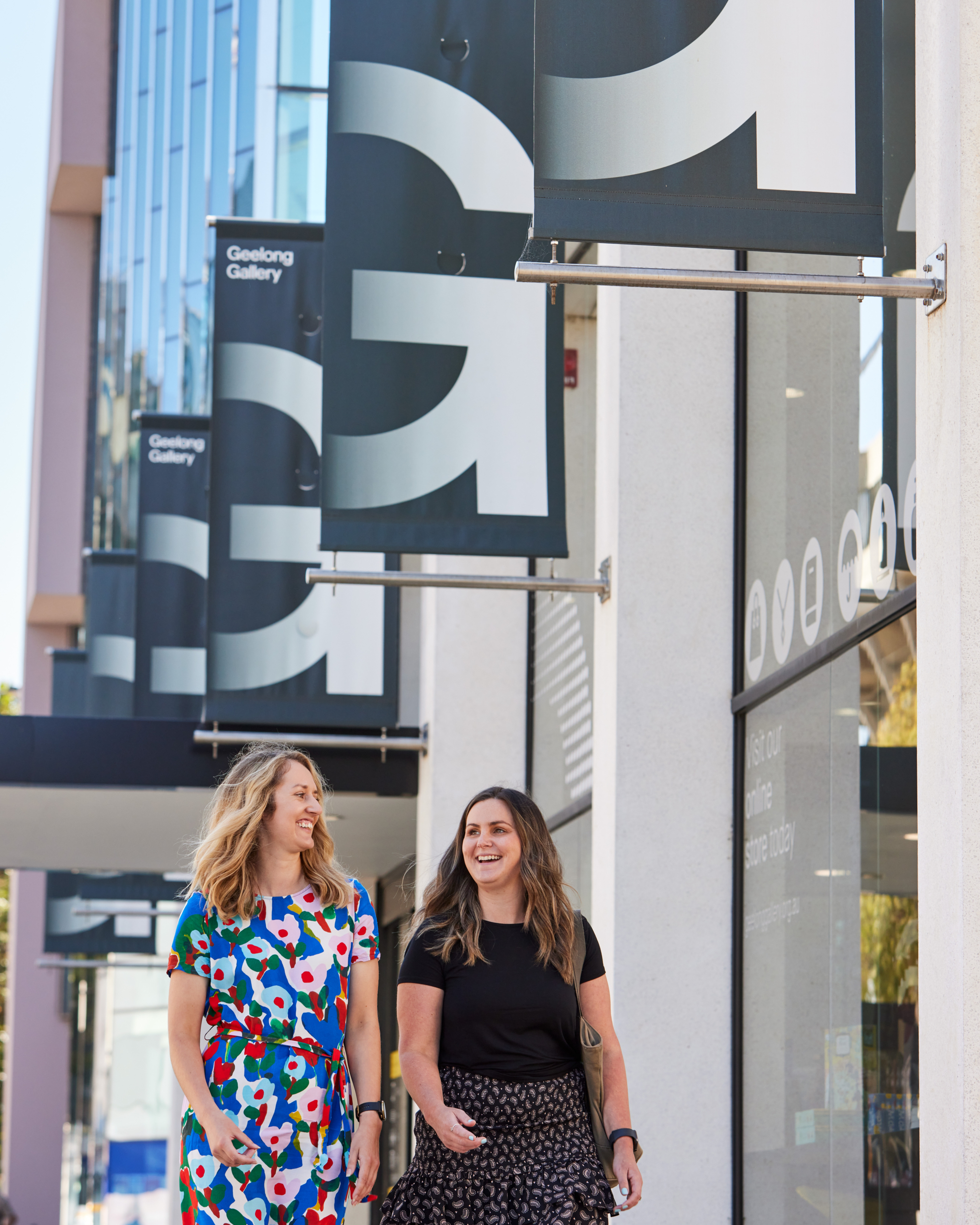 two girls walking in front of Geelong Gallery